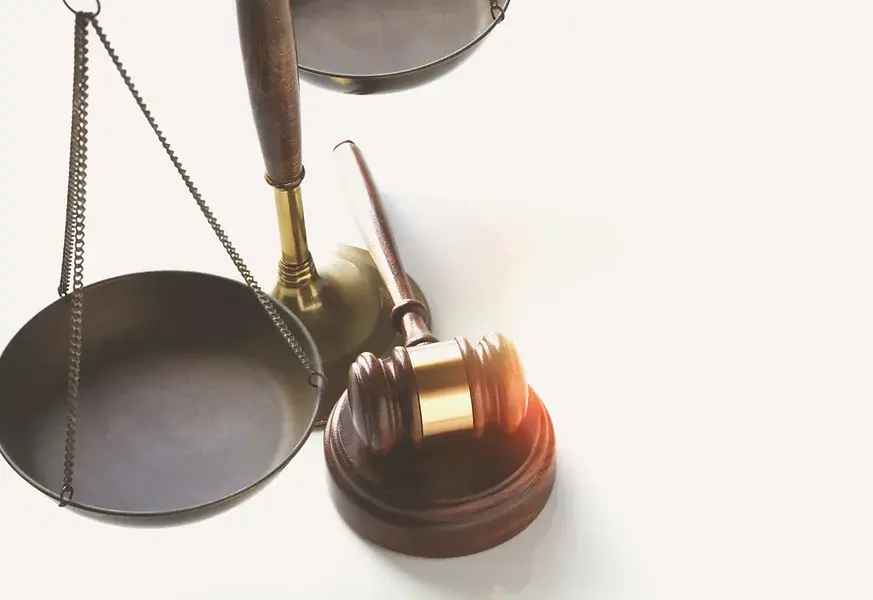 A gavel sits next to a scale, representing the justice system