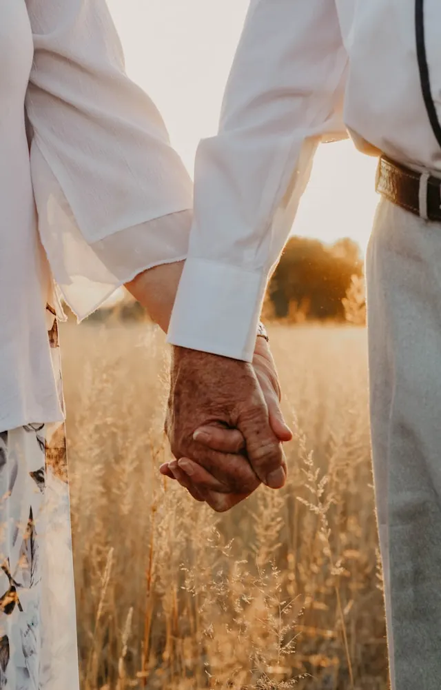 An elderly couple holding hands